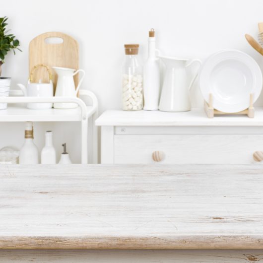 Bleached tabletop with copyspace over blurred kitchen furniture with tools